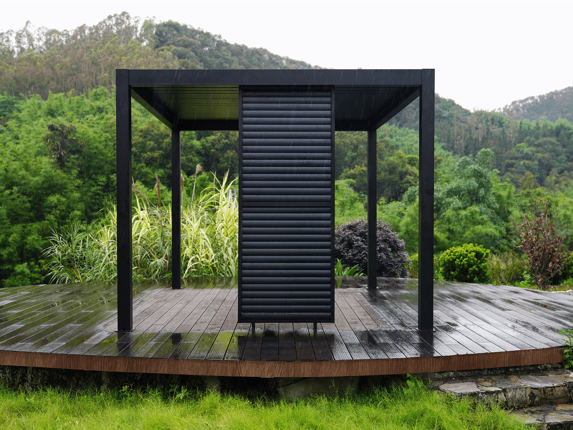 Black aluminum slat wall for Louvre 5 pergola providing privacy and shade in modern outdoor living space.