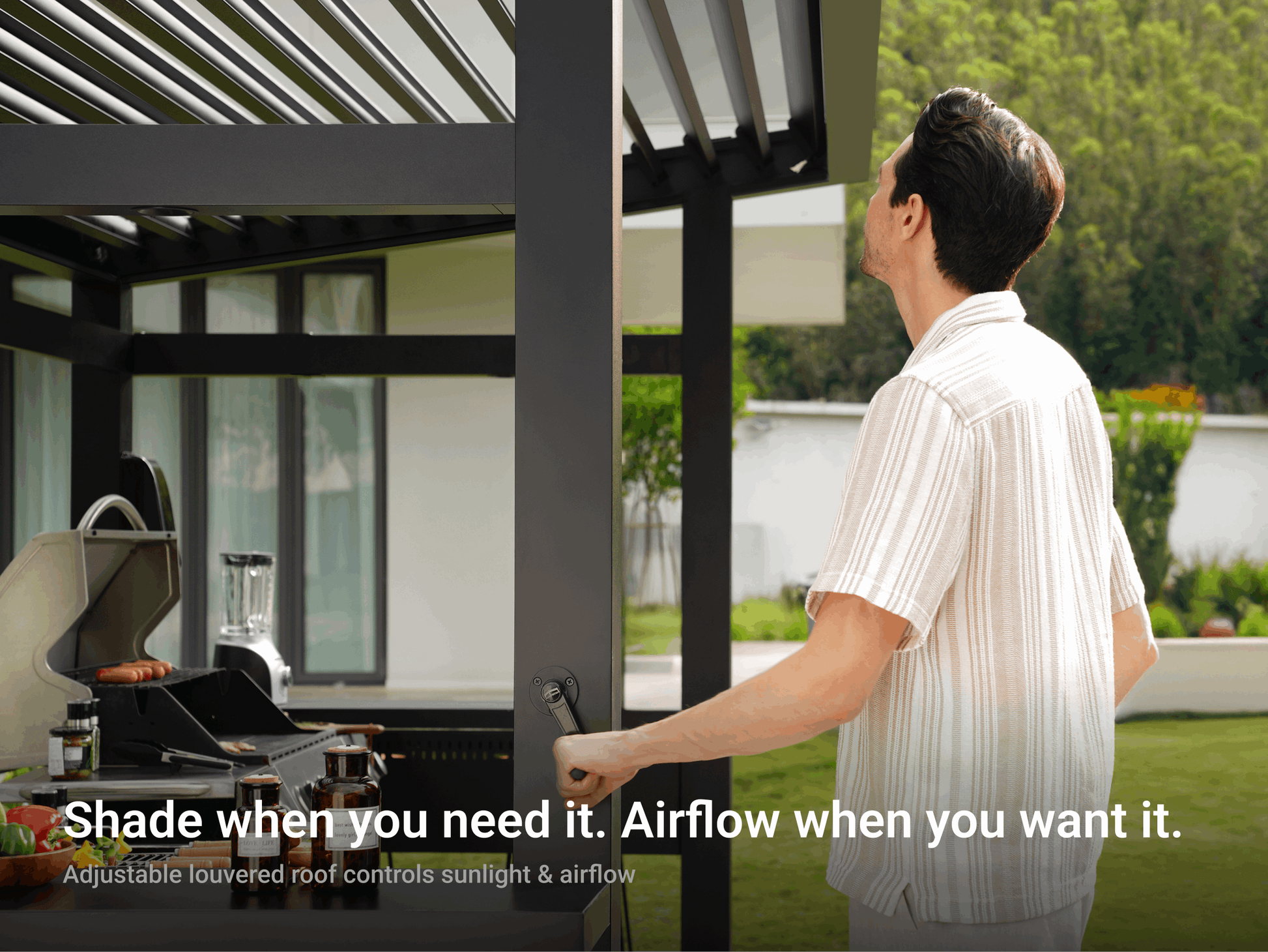 Man adjusting LuxPatio Grill Louvered Pergola Lite dark grey aluminum frame for customizable shade and airflow control.